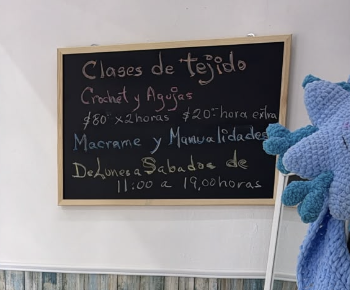 Pizarrón con horarios y precios de las clases de tejido